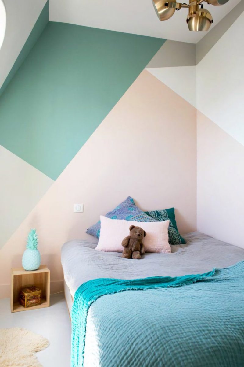 Dormitorio infantil con pared pintada creando formas geométricas